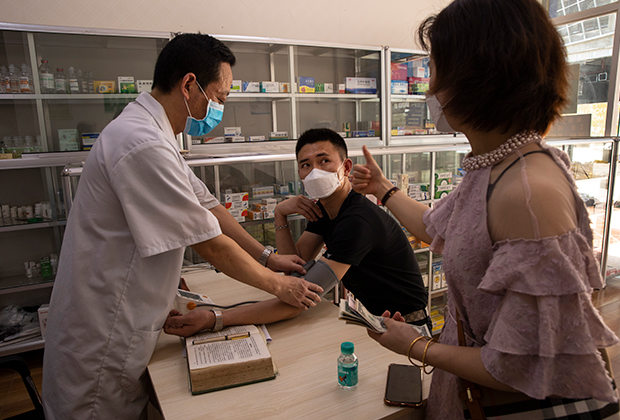 Китайский врач осматривает пациентов-китайцев в Камбодже