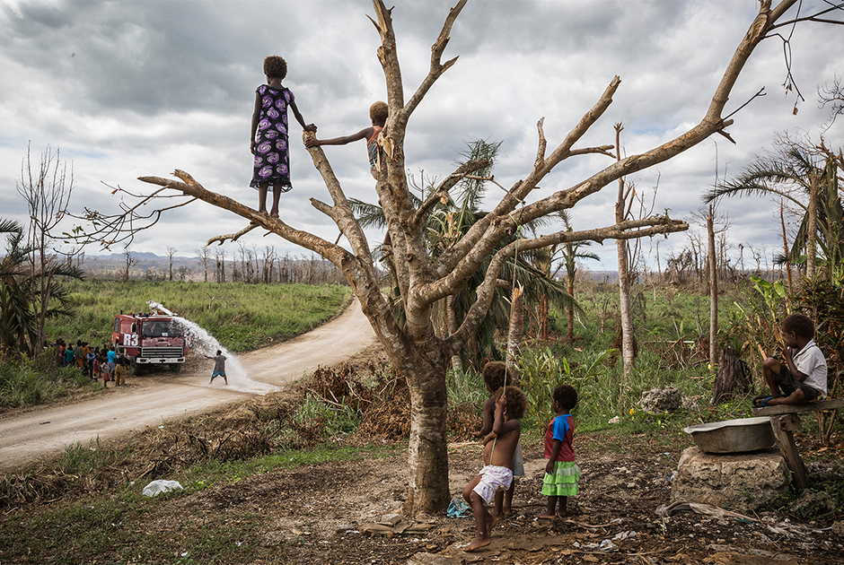 Дети из деревни Этас на острове Эфате смотрят на грузовик, доставляющий питьевую воду в к ним в деревню. После циклона «Пэм», который ударил по Вануату в 2015 году, многие местные общины лишились источников питьевой воды.