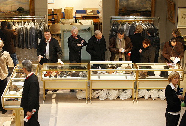 Покупатели рассматривают выставленную на торги одежду Миттерана