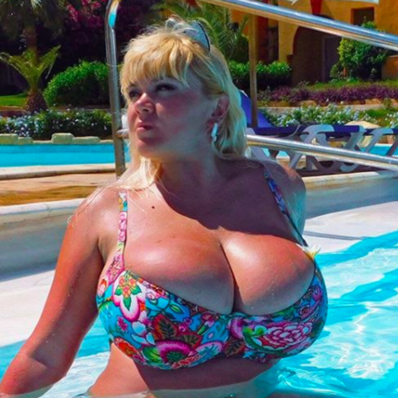 Огромная грудь дамы у бассейна