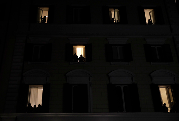 Люди смотрят из окон на приуроченную к 8 Марта демонстрацию женщин в Риме