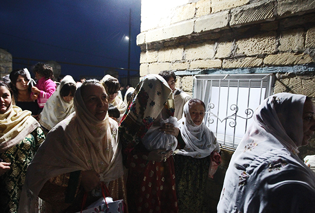 Женщины ведут невесту с платком на лице в дом жениха во время празднования свадьбы в поселке Кубачи. Республика Дагестан, Россия, 2012 год
