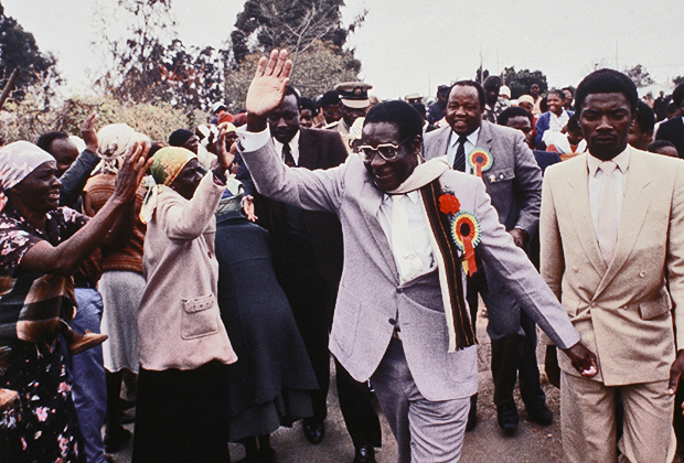 Роберт Мугабе поднимает руку в знак благодарности своим сторонникам на митинге под Хараре в июле 1985 года