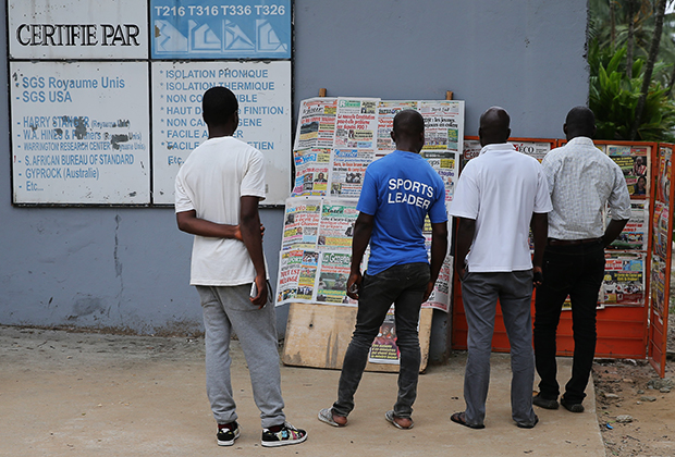 Ивуарцы читают газету на рынке