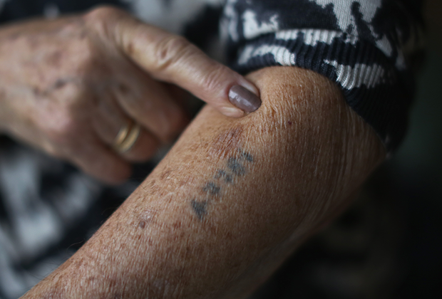 Узница концлагеря показывает татуировку с ее номером. Лондон, 2014 год