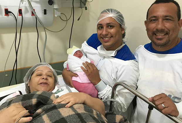 Марсело дас-Невес держит одного из своих детей рядом с матерью и отцом