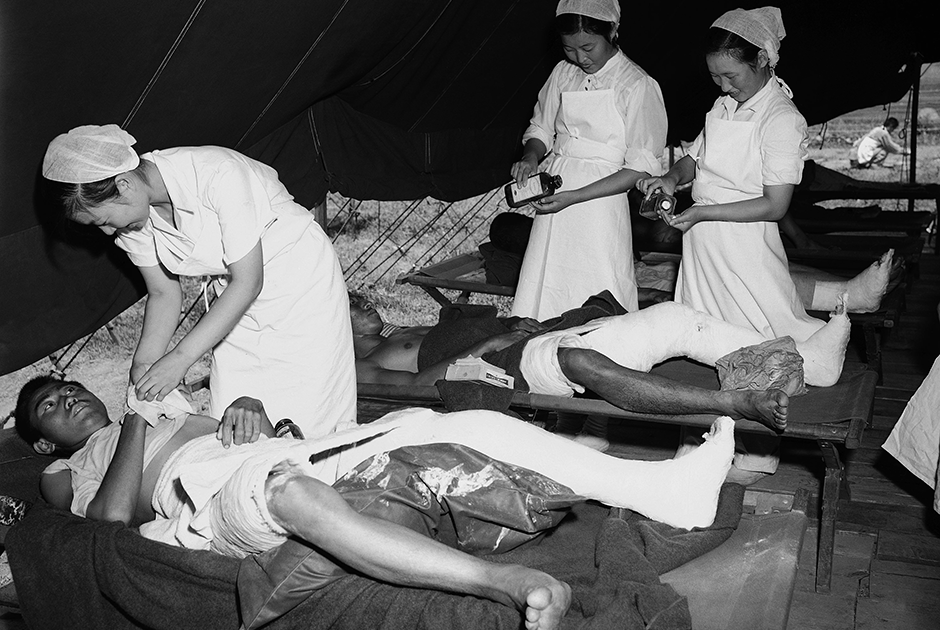 Южнокорейские медсестры ухаживают за ранеными северокорейскими пленными в лагере для военнопленных. 28 августа 1950 года.