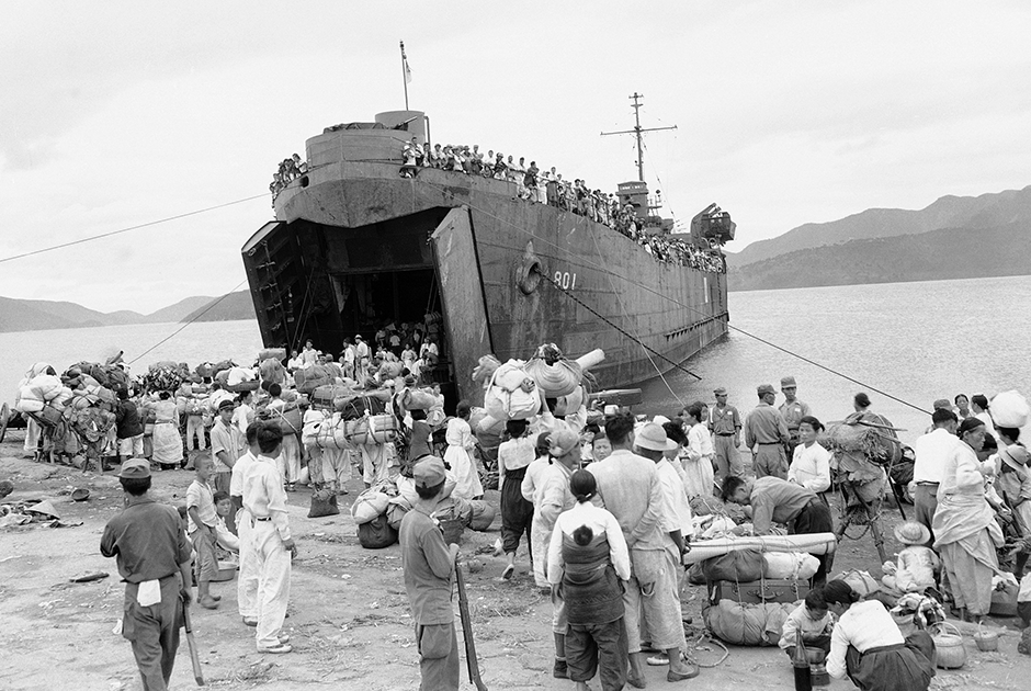 Южнокорейские беженцы эвакуируются на американском десантном корабле. Им приказали покинуть свои дома для предотвращения жертв среди гражданского населения в боях между силами Организации Объединенных Наций и армией Северной Кореи. Город Масан, Южная Корея, 17 сентября 1950 года.