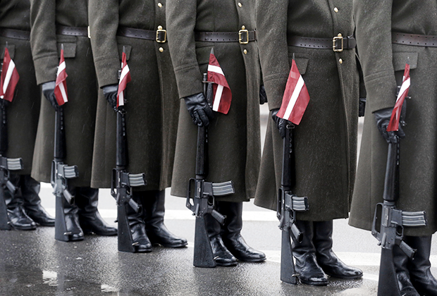 Ленты в цветах национального флага у солдат армии Латвии. Парад в честь Дня независимости