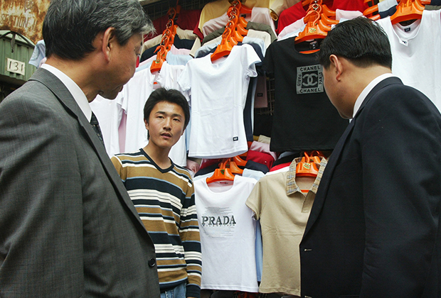 Бизнесмены выбирают фейковые футболки Prada и Chanel на улице в Пекине, которая известна своими магазинами по продаже реплик