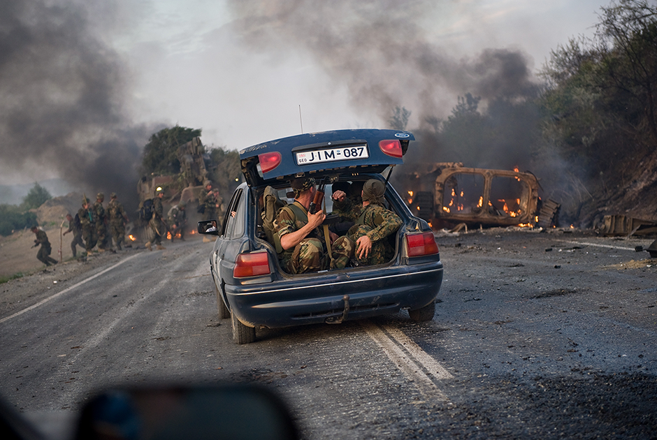 Грузинские военные, чей БТР подбили, выбираются на гражданской машине из зоны боевых действий по дороге от Гори к Тбилиси, по которой и двигались российские войска, 11 августа