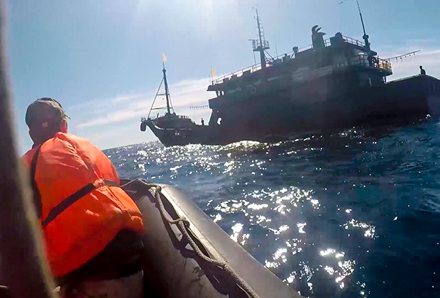 Лодка береговой охраны приближается к рыболовной шхуне КНДР