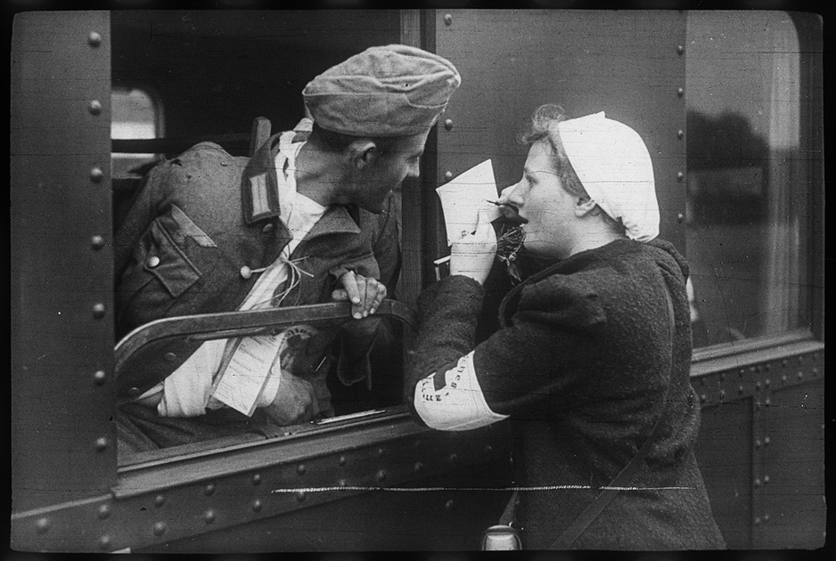 Раненый немецкий солдат и медсестра перед отправкой санитарного поезда в госпиталь. Польша, 1939 год