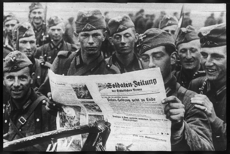 Военнослужащие вермахта читают немецкую газету «Soldaten Zeitung» (в переводе с нем. «Солдатская газета») с заголовком «Польский поход подходит к концу». Польша, 1939 год