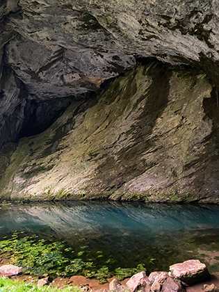 Голубое озеро у входа в портал пещеры