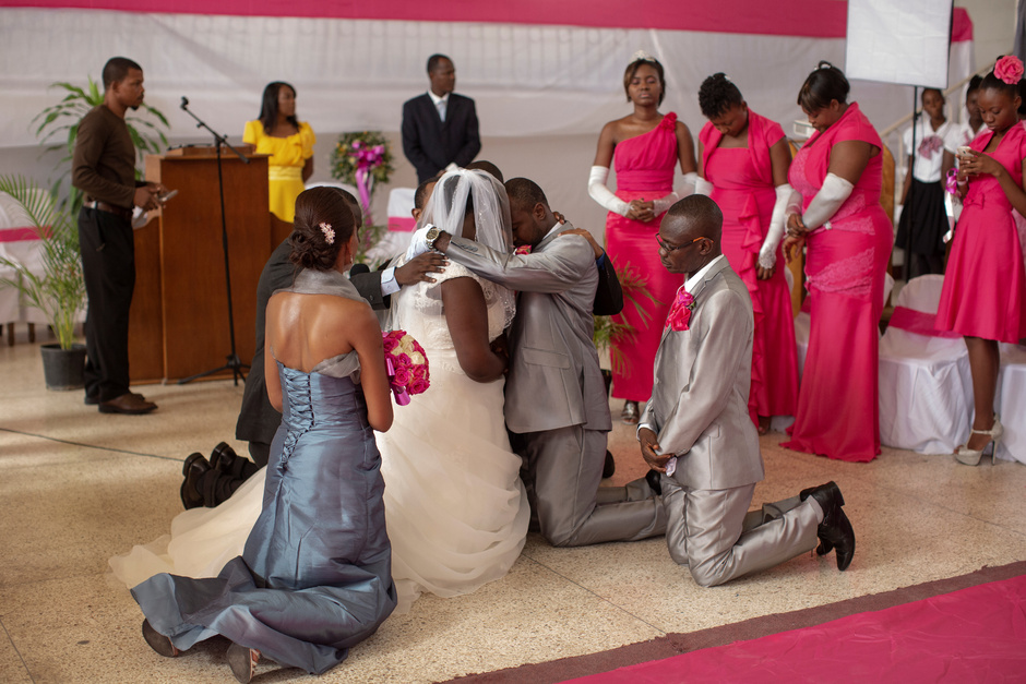 Один из самых важных моментов свадебной церемонии — получение благословения от священника. Крестные жениха и невесты стоят на коленях рядом с ними в этот ответственный момент.
