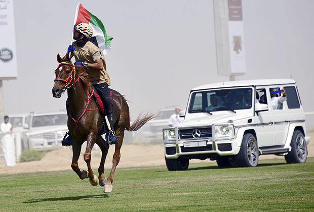 Кронпринц Хамдан бин Мохаммед бин Рашид аль-Мактум целует национальный флаг Дубая, 6 марта 2014 года