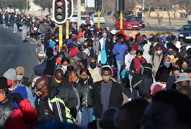 Пассажиры ждут автобуса во время забастовки водителей такси во время пандемии. ЮАР, июнь 2020 года