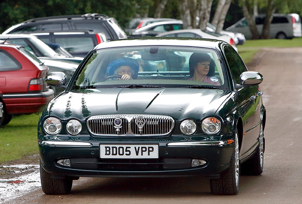 Королева Елизавета II за рулем автомобиля Daimler Jaguar в сопровождении офицера полиции Кэрол Квирк