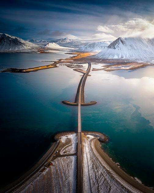Канонический пейзаж дороги в форме рыцарского меча, окруженного заснеженными вершинами гор, больше напоминает компьютерную графику, нежели существующую в реальном мире конструкцию.

Тем не менее такая трасса действительно существует — и найти ее можно на полуострове Снафедльснес в Исландии.
