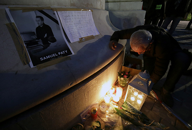 Люди приносят цветы и свечи к мемориалу убитого учителя Самуэля Пати