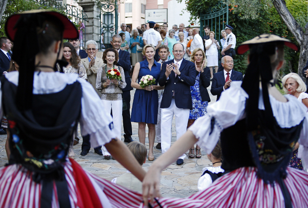 Танцоры в традиционных костюмах встречают князя Монако Альбера II и его супругу Шарлин, когда они прибывают на Pique Nique Monegasque (пикник Монако), 1 сентября 2014 года