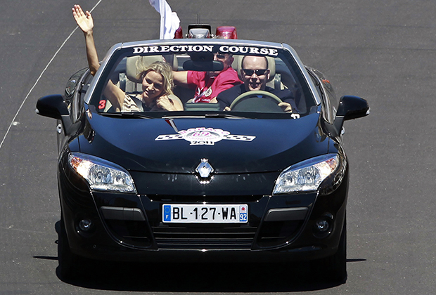 Князь Монако Альбер II и его невеста Шарлин Уиттсток едут по трассе перед стартом Гран-при Монако F1, 29 мая 2011 года