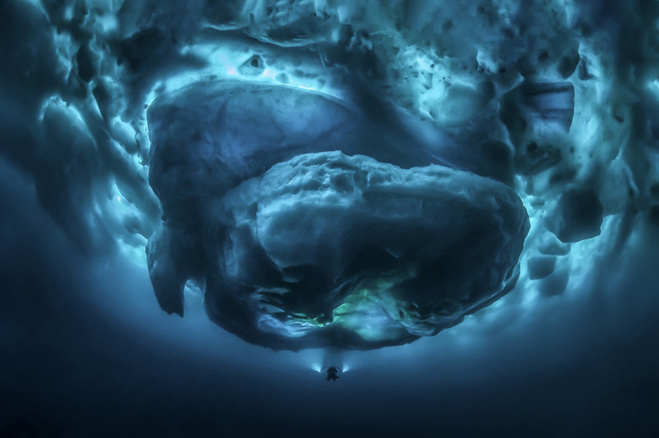 Фотограф Тобиас Фридрих (Tobias Friedrich) запечатлел ночной спуск дайвера под воду с температурой ниже нуля. Особенно впечатляющим этот снимок делает то, что над водолазом — громада айсберга. За счет ракурса фото приобретает мистический оттенок.
