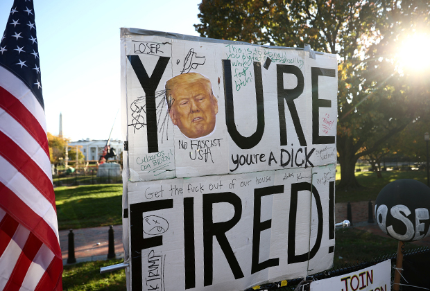 Плакат «Ты уволен!» на ограде Белого дома