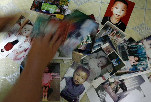 Фотографии пропавших детей в доме одной из матерей из города Дунгуань