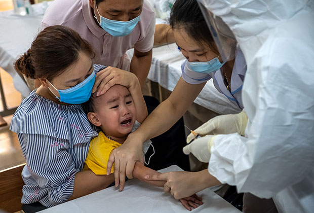 Вьетнамские медики берут у ребенка кровь для анализа на COVID-19