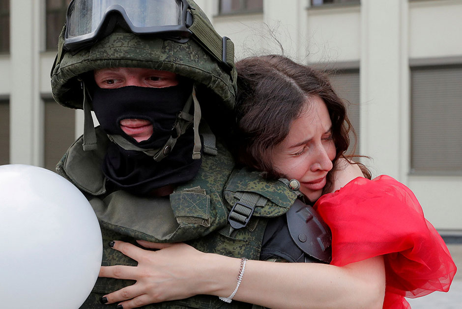 Девушка обнимает военного на площади Независимости в Минске во время акции протеста против результатов президентских выборов. 14 августа митингующие подошли к Дому правительства республики, рядом с которым стояли несколько военных в защитном обмундировании. Когда протестующие подошли вплотную к силовикам, они не предпринимали никаких действий и опустили щиты. Это был один из немногочисленных случаев ненасилия по отношению к митингующим, отмечает запечатлевший этот момент фотограф. 