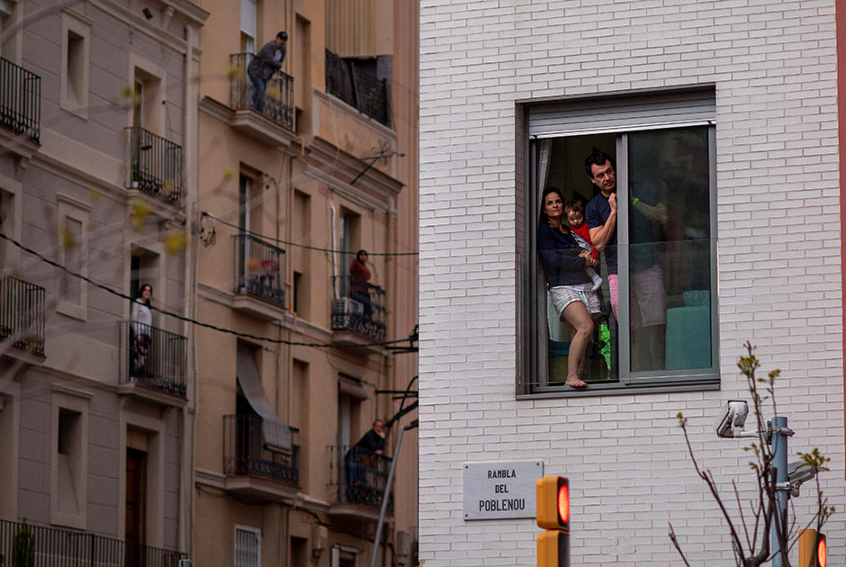 Весной 2020-го года многие страны мира столкнулись с новым типом коронавируса. Из-за недостатка информации об опасности инфекции власти государств вводили жесткие меры, минимизирующие контакты людей друг с другом, вплоть до ограничений на их передвижение. На снимке — жители Испании выглядывают с балкона своей квартиры во время самоизоляции в Барселоне.