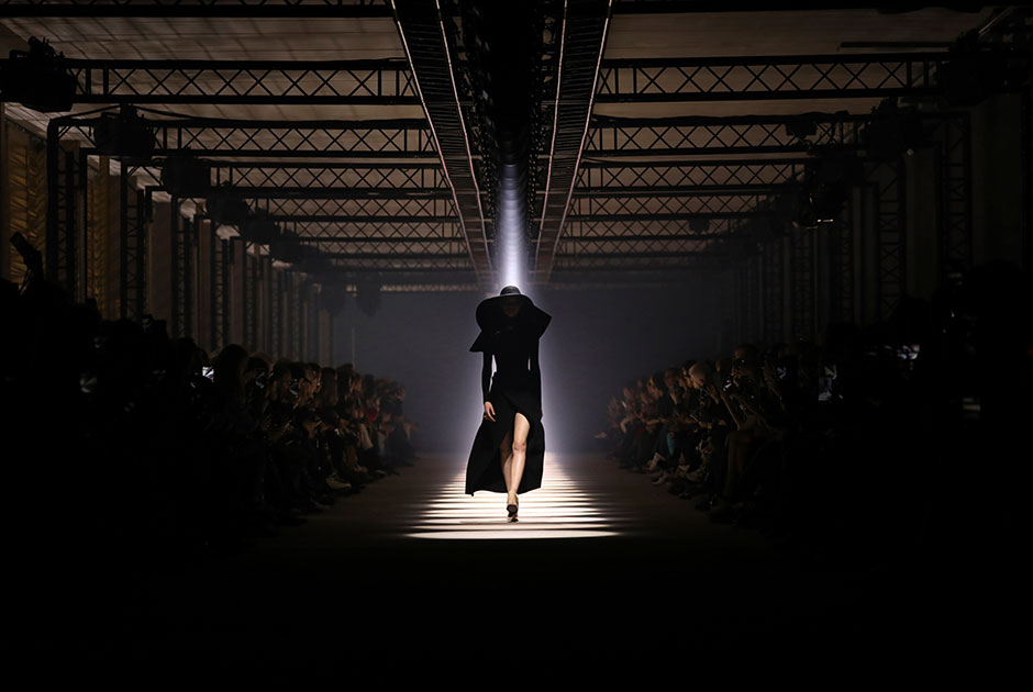 Модель демонстрирует новую коллекцию французского модного бренда Givenchy во время недели моды в Париже. Снимок сделан 1 марта, еще до введения различных ограничений  из-за пандемии. Буквально через несколько месяцев защитные маски на лице станут нормой, а люди будут стараться соблюдать расстояние в 1,5-2 метра друг от друга в том числе и в зрительных залах. Многие мероприятия будут отменены или переведены в онлайн-формат.