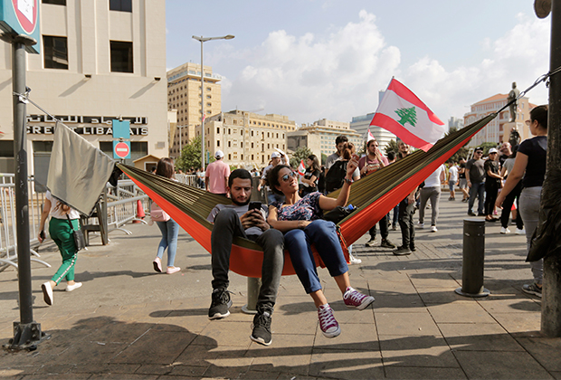 Демонстранты отдыхают в гамаке во время протестов в Бейруте