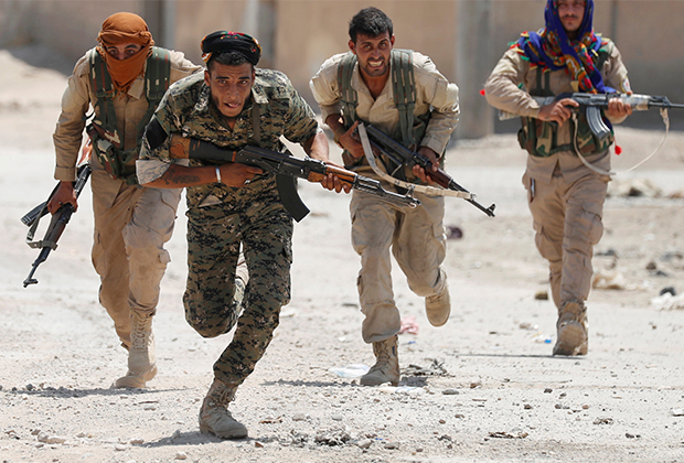 Курдские боевики перебегают улицу в городе Ракке, Сирия