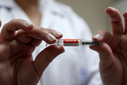 Бразильская медсестра держит дозу китайской вакцины CoronaVac