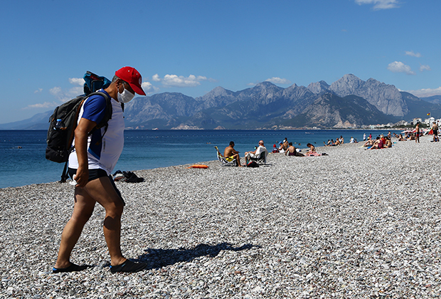 Турист в защитной маске на одном из пляжей Антальи в Турции. Июнь 2020 года