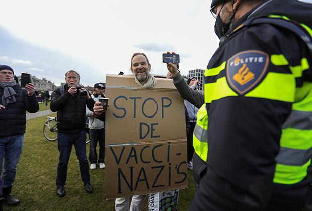 Протестующий с плакатом «Остановите вакцинацистов» в Амстердаме 24 января