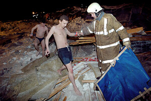 A rescuer helps Transvaal water park visitors wearing only swimsuits to leave through the debris of its collapsed roof, in Moscow, late Saturday, Feb. 14, 2004. The vast glass roof covering a Moscow water park collapsed Saturday evening, killing at least eight people, injuring nearly 70 and trapping others under the rubble, according to Russian news agencies. The temperature in Moscow dropped to minus 17 degrees Celsius (2 degrees Fahrenheit) on Saturday. (AP Photo/ Anatoly Zhdanov, Komsomolskaya Pravda)