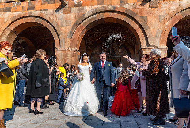 Новобрачные выходят из церкви после венчания, город Вагаршапат, Армения