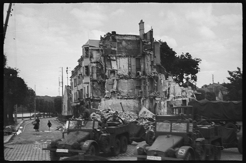 Колонна немецких войск движется по разрушенному городу. Франция, 1940 год.