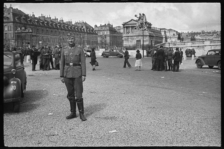 Немецкий военный позирует на фоне дворца в Версале. Франция, 1940 год.