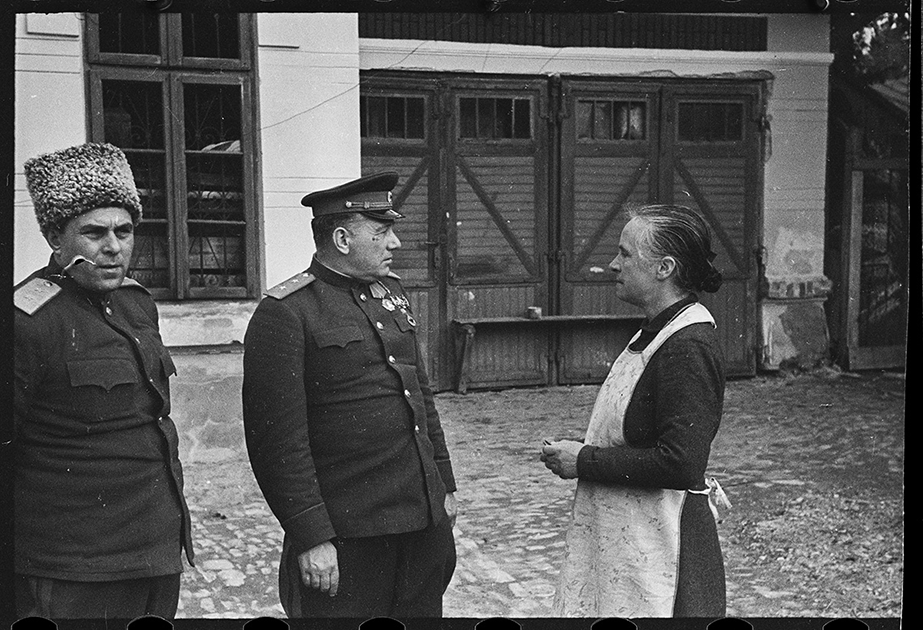 Генералы Филипп Жмаченко и Иван Сусайков беседуют с жительницей города, британской подданной. Ботошани, Румыния. Апрель 1944 года.


