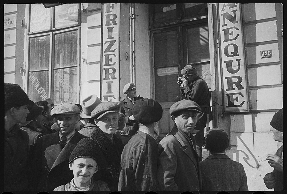 Советский фотокорреспондент снимает людей на улице города. Ботошани, Румыния. Апрель 1944 года.
