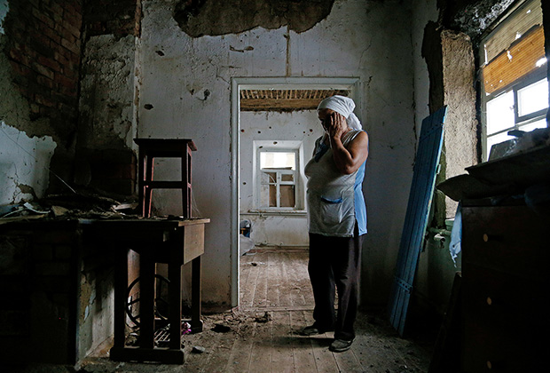 Жительница Донбасса в своем разрушенном доме