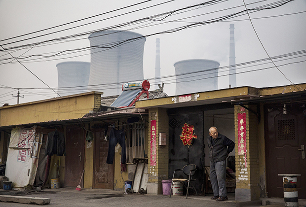 Житель бедного района у своего дома, Пекин, 2014 год