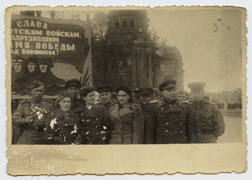 У здания Рейхстага перед плакатом «Слава советским воинам, водрузившим знамя Победы над Берлином!». Берлин, 1945 год.

