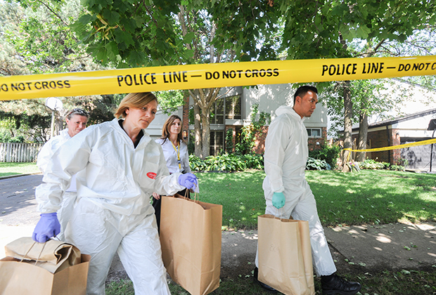 Детективы выносят пакеты с уликами из дома Харрисонов после смерти Калеба