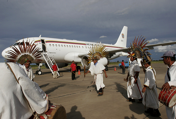 Коренные боливийцы танцуют перед самолетом президента Венесуэлы Уго Чавеса во время его визита в разрушенный наводнением город Тринидад, примерно в 400 километрах к северо-востоку от Ла-Паса, 10 марта 2007 года